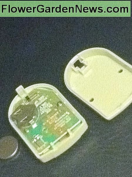 De garagedeur sensor bestaat uit een eenvoudige printplaat, de twee helften van de behuizing en een lege batterij. The garage door sensor consists of a simple circuit board, the two halves of its case, and a flat battery.