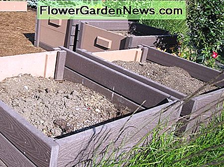 Kompostbehälter sind in einer Ecke des Testgartens versteckt und mit Grasgras abgeschirmt. Compost bins are tucked into a corner of the test garden and screened with prairie grasses.