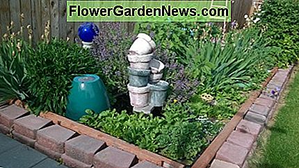 Gemeinsame Salbei mit lila Blüten bildet eine üppige und dramatische Kulisse für toskanisch inspirierten Brunnen. Landschaftsgestaltung von Nancy Owens, Common cooking sage with purple blooms forms a lush and dramatic backdrop for Tuscan inspired fountain. Landscape Design by Nancy Owens,