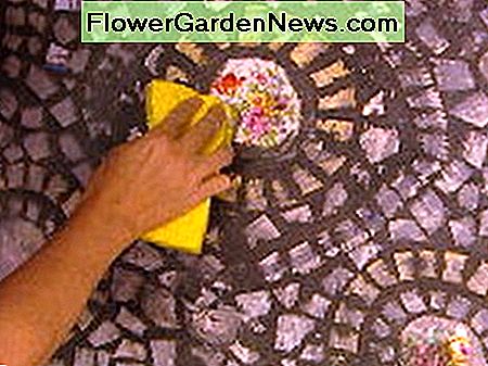 Svamprensning overskydende fugemasse fra gulvfliserne. Sponge-cleaning excess grout from the floor tiles.