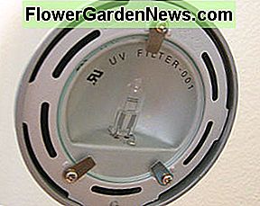 Eine Halogenlampe hinter einem runden UV-Filter. Ein separater Filter ist im Lieferumfang einiger Halogenlampen enthalten, um UV-Licht zu entfernen. A Halogen lamp behind a round UV filter. A separate filter is included with some halogen light fixtures to remove UV light.