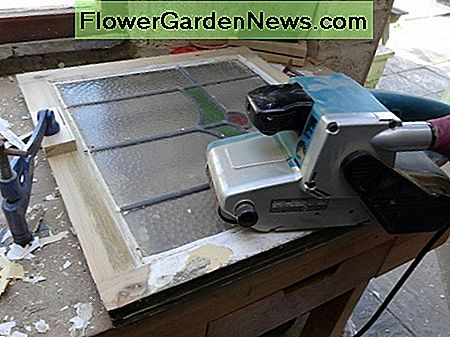 Gebruik een schuurmachine om de raamkozijnen terug naar het kale hout te brengen. Using a belt sander to clean take the window frames back to the bare wood.