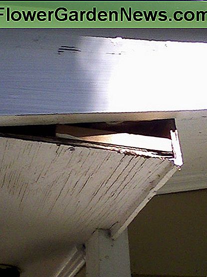 Blok beveiligd; de schroefkop is zichtbaar tegen het binnenwelvingbord. Een tweede schroef, ongezien in dit perspectief, beveiligt ook het rechter uiteinde. Block secured; the screw head is visible against the soffit board. A second screw, unseen in this perspective, secures the right end as well.