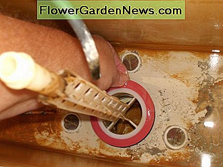 Cette bague en caoutchouc rouge est le joint de la valve de chasse. Retirez-le et remplacez-le par un nouveau. That red rubber ring is the flush valve seal. Remove it, and replace with a new one.