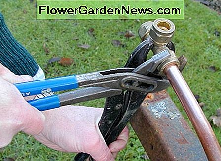 Užveržkite veržlę ant suspaudimo montavimo su vandens siurblių replėmis Tightening a nut on a compression fitting with a water pump pliers