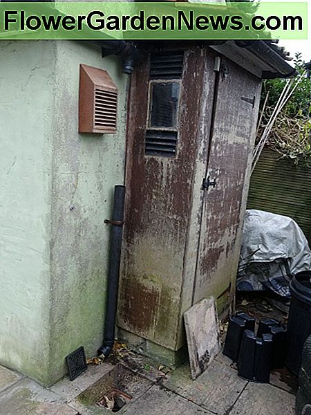 De oude tuinbehuizing werpt de deur open The old garden tool shed door