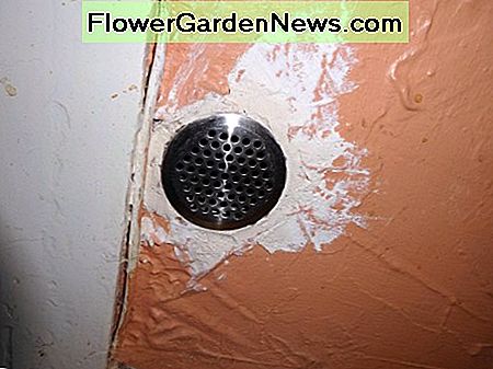 Luchtrooster aangebracht over oude overtollige gasinlaatbuis in hal Air vent fitted over old redundant gas inlet pipe in hall