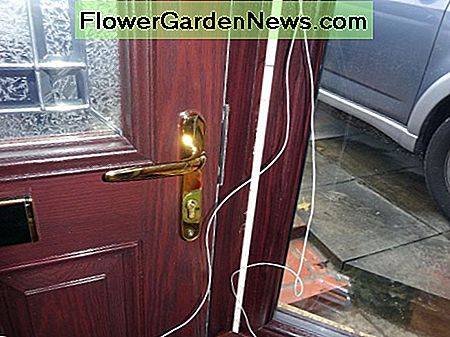 Bellendraad naast nieuw deurkader klaar om hoewel voorgeboord gat aan de buitenkant te voeden. Bell wire next to new door frame ready to feed though predrilled hole to the outside.