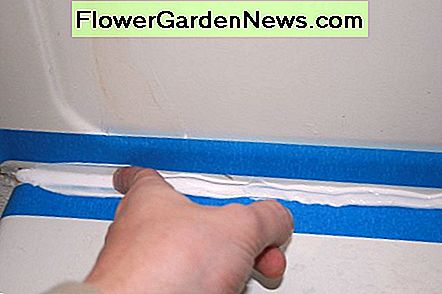 Brug din finger til langsomt og let at trække tætningen og give den en glattere finish. Use your finger to slowly and lightly drag the caulk and give it a smoother finish.