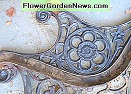 Sehen Sie den Rost und den Schmutz auf dem Gusseisenende der Bank See the rust and dirt built up on the cast iron end of the bench