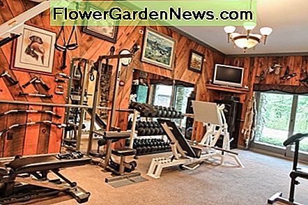 Vackert rustikt hem gym med lodge KÀnsla med inramade mÄlningar av jakt scener och taxidermi fula dekorera vÀggarna Beautiful Rustic Home Gym with a Lodge Feeling with framed paintings of hunting scenes and taxidermy foul decorating the walls