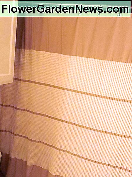 Duschvorhang mit Waffelgeflecht verleiht dem Badezimmer eine gemütliche, warme Textur. Waffle weave shower curtain adds cozy warm texture to the bathroom.
