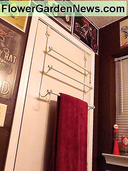 Verwenden Sie einen Handtuchhalter, um mehr Platz für Ihre Wanddekoration zu schaffen. Use an over-the-door towel rack to give you more wall space for your wall decor.