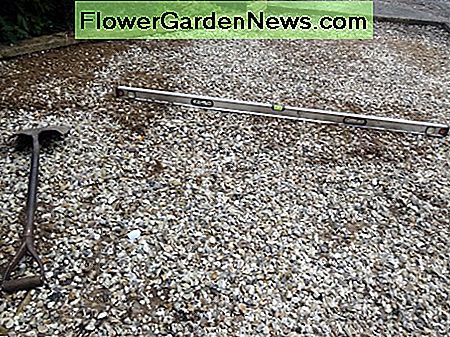 Mit Wasserwaage und Schaufel den Kies ebnen. Using spirit level and shovel to level the gravel.
