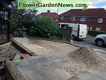 Absenken des vorhandenen Kieswerks um 2 Zoll auf die erforderliche Tiefe für das Verlegen der Kunststoffgitter. Lowering existing gravel drive by 2 inches to the required depth for laying the plastic grids.