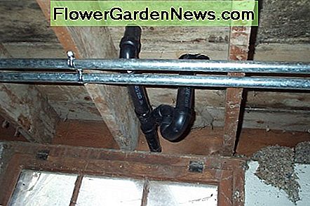 Die fertigen Rohrleitungen unter dem Badezimmer (einschließlich der Ablauf für Waschbecken und Badewanne). Die nach links laufenden galvanisierten Rohre gehen direkt durch den Boden zur Pumpe. The finished plumbing under the bathroom (including the drain for both sink and bathtub). The galvanized pipes running toward the left go directly through the floor to the pump.