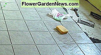 Vloertegels voegen een high-end afwerking toe aan een wasruimte. Floor tiles add a high-end finish to a laundry room.